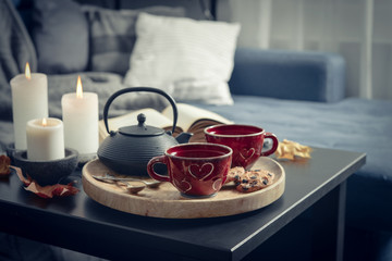 Two cups of tea on a serving tray on coffee table.