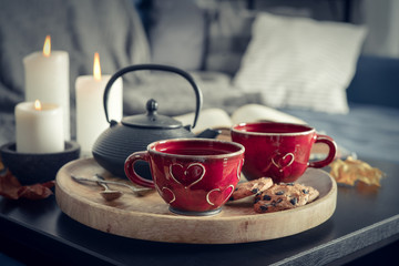 Two cups of tea on a serving tray on coffee table.