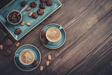 Two cup of coffee and plate with chocolate cookies