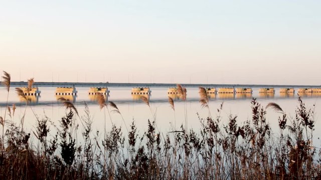 Low water bridge from Sedanka to the De Friz peninsula across the Amur Bay of Primorsky Krai Russia against the background of a red sunset sky. Far Eastern landscape. Soothing country scene.