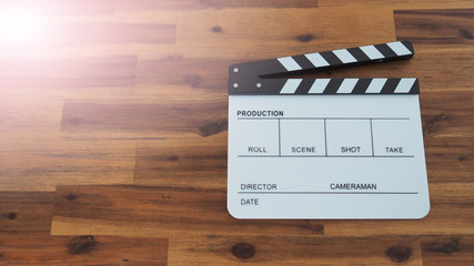 Clapperboard or clap board or movie slate with black director chair use in video production , movie, cinema industry on wood background with flare light.
