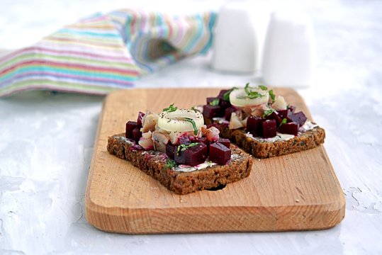 Smorrebrod, a traditional Danish open sandwich on rye bread with herring and pickled beets.
