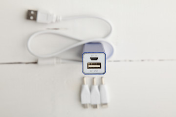 USB cable in white, adapter for charging and adapters on a white background
