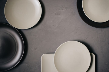 Top view of set ceramic dishes brown and milky white colored, on gray background