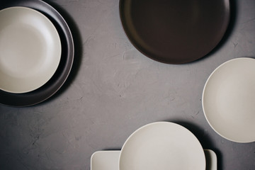 Top view of set ceramic dishes brown and milky white colored, on gray background