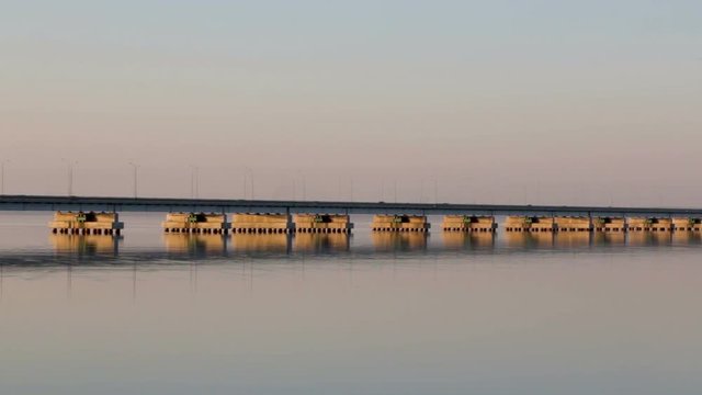 Low water bridge from Sedanka to the De Friz peninsula across the Amur Bay of Primorsky Krai Russia against the background of a red sunset sky. Far Eastern landscape. Soothing country scene.