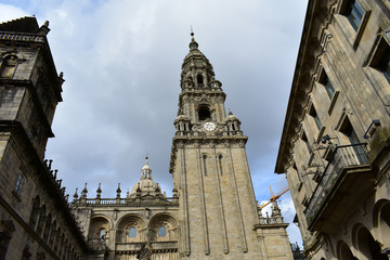 Cathedral. Baroque clock tower and Platerias romanesque facade. Autumn, cloudy grey sky. Santiago de Compostela, Spain.