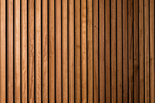 Background of interior vertical timber panelling with subtle fall off of light and focus to the right, suitable for backdrop for corporate portraits in business environment 