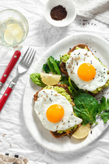 Top view healthy avocado toasts breakfast lunch fried eggs white background lemon water