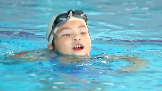 Thai child swimming in the indoor pool
