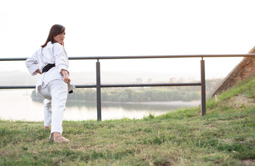 A young karate professional practicing while wearing a black belt.