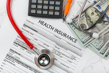 Health insurance application form with banknote and stethoscope concept