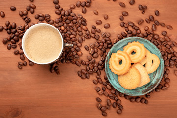 A photo of coffee in a vintage cup, shot from the top with coffee beans and Danish butter cookies, with a place for text