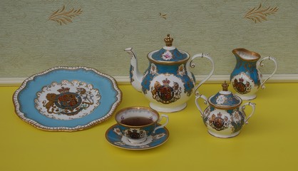 English teacup with saucer, teapot, sugar bowl, cream jug and a cake plate with an English coat of...