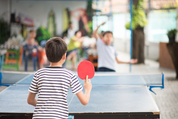 Kid playing table tennis outdoor with family - 234226417