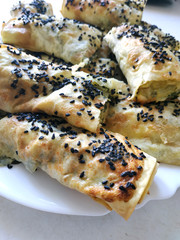 Homemade prepared cutted lavash pieces with vegetables. Burek with spinach and cheese and black cumin. Yufka