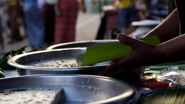 sweet Mae Hong Son local delicacy made from coconut milk and brown sugar being sold and served at a market in Northern Thailand