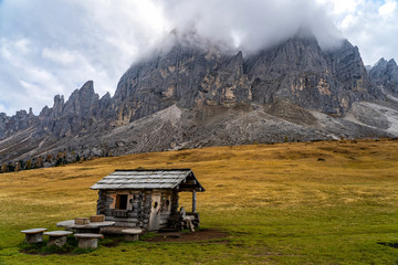 Obraz premium Wooden shed on a grassy meadow in a mountains.