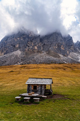 Obraz premium Wooden shed on a grassy meadow in a mountains.