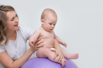 mother and her baby doing exercises on a ball