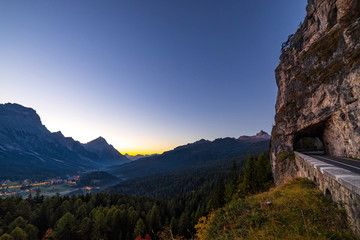 Obraz premium Early morning view of beautiful Dolomites mountains in Italian Alps with mountain road and tunnel.