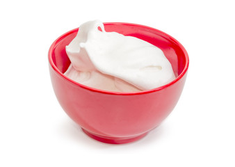 Beaten egg whites in the red ceramic bowl