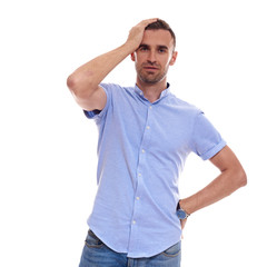 Casually handsome. Confident young handsome man in jeans shirt keeping arms crossed and smiling while standing against white background