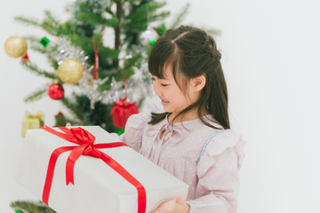 Fototapeta na wymiar Asian cute girl child happy smiling with her big gift present at christmas party.