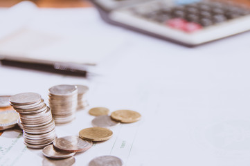 Silver coins placed in piles on desk with light sunset and instagram style filter photo vintage tone