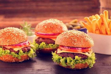 Hamburger with beef meat and fresh vegetables on wooden background