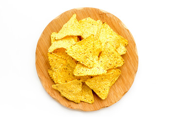Snack for party. Make potato chips. Crispy potato chips on wooden cutting board on white background top view
