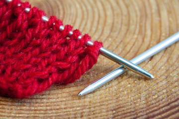 Red knitting wool, knitting needles.