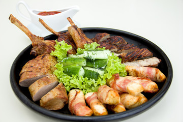 grilled meat, grilled meat and vegetables in a cast iron pan with sauce