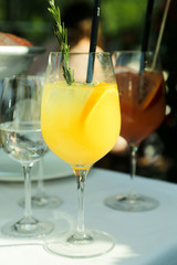 Glass of refreshing orange cocktail on table in restaurant