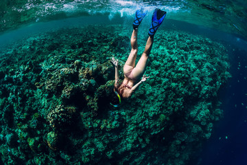 Woman free diver dive in the tropical ocean