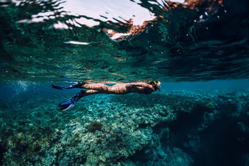 Freediver woman swimming in the tropical ocean