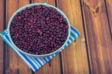 The concept of natural healthy food. Plate with grains of red beans closeup