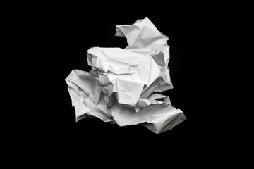 crumpled square lump of white paper on a black background