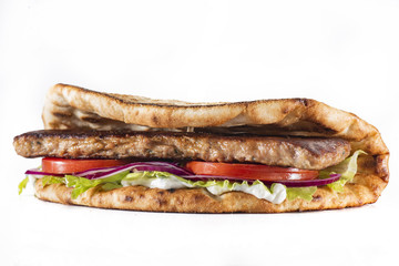 Greek pita with meat, salad, tomato and sauce isolated on white