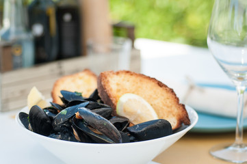  black mussels with crispy bread on a plate