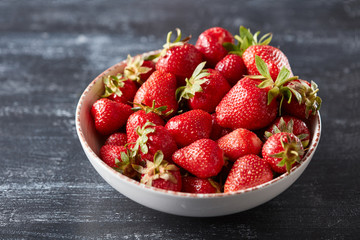 Organic homemade strawberry berries in a bowl on a black concrete background with copy space. Vitamin berry