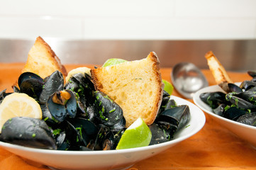 black mussels with crispy bread on a plate