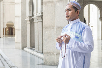 Middle age muslim man praying at mosque.