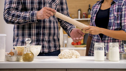 Young man baking something sweet for him and his wife. Time for sweet cooking.