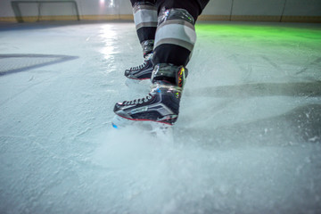 Many black pucks are organized in a line on the ice.