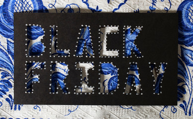 Words BLACK FRIDAY are cut out from black carton paper. Closeup