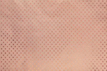Rose gold background from metal foil paper with a stars pattern