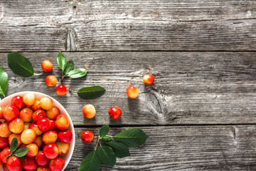 Fresh cherry on plate on wooden background, ripe cherries, sweet fruit, top view