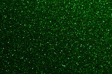 Dark green sparkling background from small sequins, closeup. Brilliant backdrop.