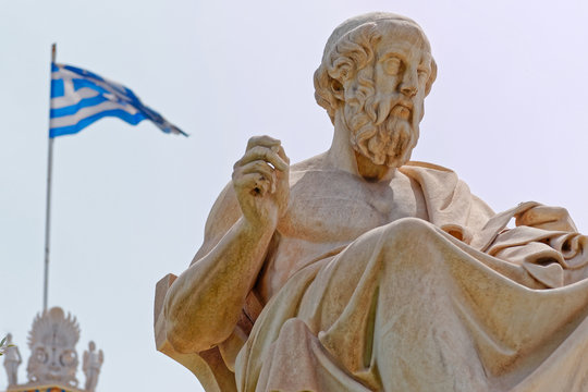 Athens Greece, Plato the famous ancient greek philosopher and a greek flag blurred in the background